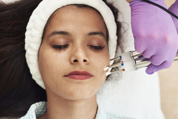Beautician using electrical impulses for healthy, firm, toned skin. Microcurrent medicine treatment. Beauty young woman