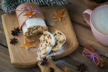 Christmas Stollen sliced on a wooden board with cinnamon stick and anise stars