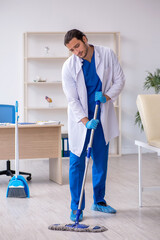 Young male contractor disinfecting clinic in pandemic concept