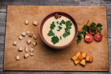 Pumpkin cream soup in a plate on a wooden table