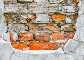 The texture of an old wall of red, orange uneven bricks with gray cement and concrete. Photography,...