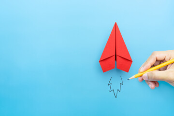 Startup concept, Red paper plane and businessman hand drawn launching plane on blue background,...