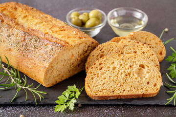 Fresh baked Ciabatta with tomatoes, herbs and spices  closeup on stone board