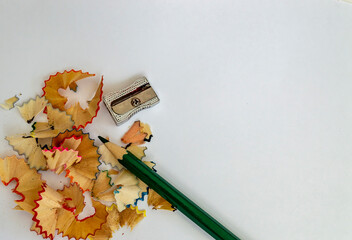 wood shavings from colored pencils and a pencil sharpener on a white background