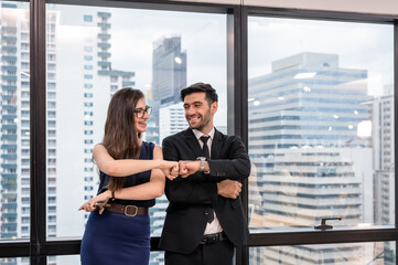 Young caucasian business partner giving fist bump and hapiness in the office at downtown