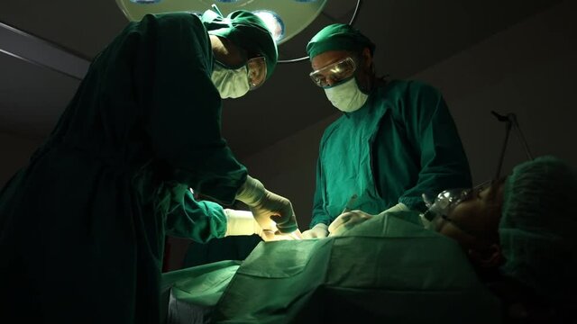 The surgeon is working in a hospital operating room.
