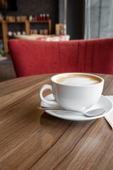 closed-up of hot drink coffee in white mug on brown wood table