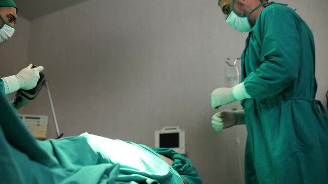 Doctors are helping patients with machines defibrillation.