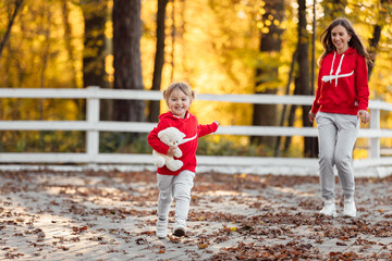 father, mother and little daughter are walking in the autumn park, happy family is having fun outdoors. father's, mother's and baby's day