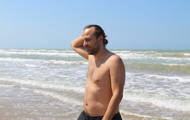 Fototapeta na wymiar Uomo in vacanza al mare in estate - relax e divertimento
