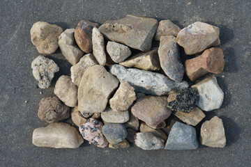 Medium-sized gravel lined in the form of a rectangle on a background of asphalt