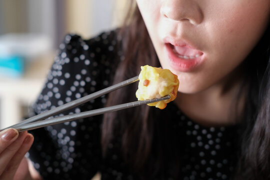 Asian Girl Eating Dim Sum In Chinese Restaurant