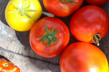 Tomatoes red and yellow in a saucer on a wooden table close up