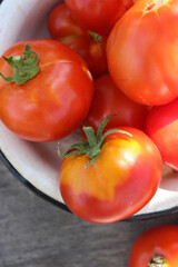 Tomatoes red and yellow in a saucer on a wooden table close up