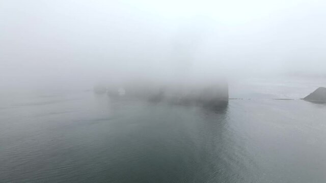 Perce Rock On A Foggy Morning By The Saint Lawrence Gulf In Quebec, Canada. - aerial drone