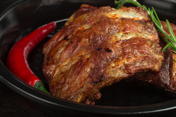 Baked pork ribs with rosemary and hot pepper, closeup