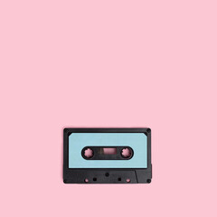 Fototapeta premium Cassette tape on a pink background. Minimal composion with copy space.