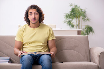 Fototapeta premium Young male student preparing for exams at home