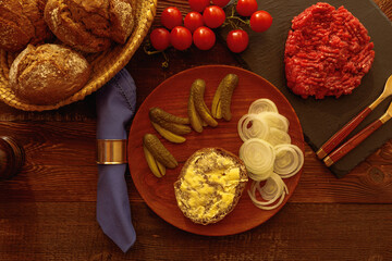Minced meat tomato onion pickled cucumber on plate with bread in basket