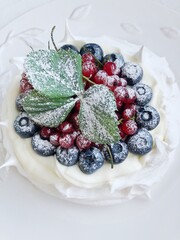 Anna Pavlova dessert with blueberries and red currants
