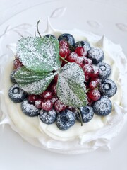 Anna Pavlova dessert with blueberries and red currants