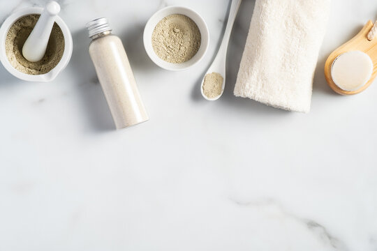 Ayurvedic face pack/mask using Gram flour/besan, haldi ubtan placed in bowls , scrub and white towel on marble table.