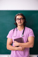 Young male student in front of board