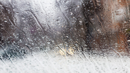 Drops Of Rain On Glass Background. Street Bokeh Lights Out Of Focus. Abstract Backdrop