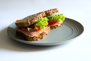 Sandwiches with vegetables and meat on a gray plate. White background. Close up