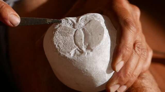 carving a pipe in alabaster stone 