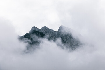 Peaks of mountains near Kranjska Gora, Slovenia, looking out of dramatic clouds, mist and fog