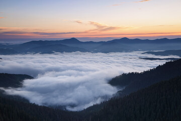 Sunrise. Amazing landscape with high mountains, fog and sky. The early morning mist. Majestic spring day. Dense fog with beautiful light. Free space for text.