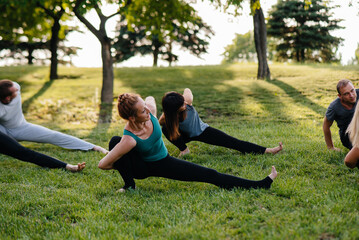 A group of people do yoga in the Park at sunset. Healthy lifestyle, meditation and Wellness