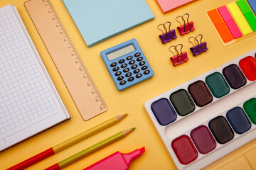 School supplies on yellow background. Back to school abstract background. Creative flat lay.