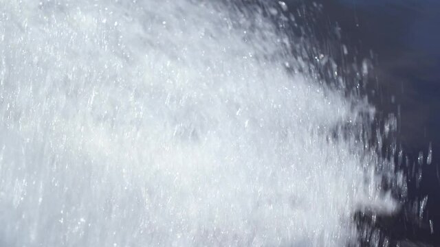 4k video footage of motor boat water traces in blue river. Closeup view of splashing white water.