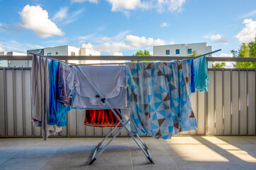 Fototapeta Suszarka z praniem stoi na balkonie, słoneczny dzień.  obraz