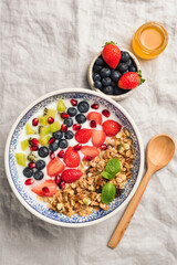 Granola bowl with berries, fruits and natural yogurt. Layered healthy breakfast cereal bowl. Top view