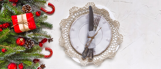 Christmas table setting, menu concept composition, decorated with pine tree branches, spices. Christmas light background, frame made of fir twigs, cones, berries. Flat lay, top view, copy space.