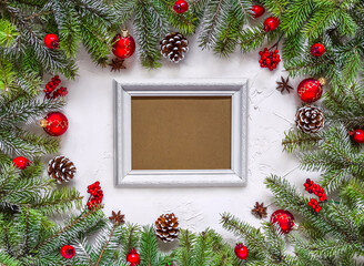 Fototapeta na wymiar Christmas white grunge background and frame for wishes. Top view, fir twigs, berries, baubles. Christmas, New Year decoration, pine tree branches and cones, light background, flat lay, copy space.