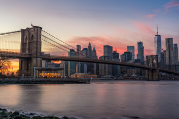 Fototapeta na wymiar Colorful Pink Sunset Behind The Brooklyn Bridge and New York Skyline