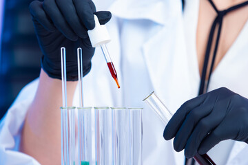 Test tubes and hands of a Chemist with a pipette close-up. Interaction of chemical liquids. Medical...