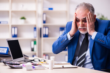 Old face injured employee sitting in the office