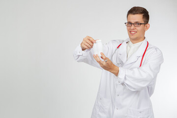 The concept of probiotics. A young smiling doctor with bottles of probiotic drink. Medical recommendations. Medical advice. Friendly doctor on a white background. Place for text.