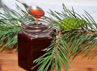 Pine twig and a jar of pine honey
