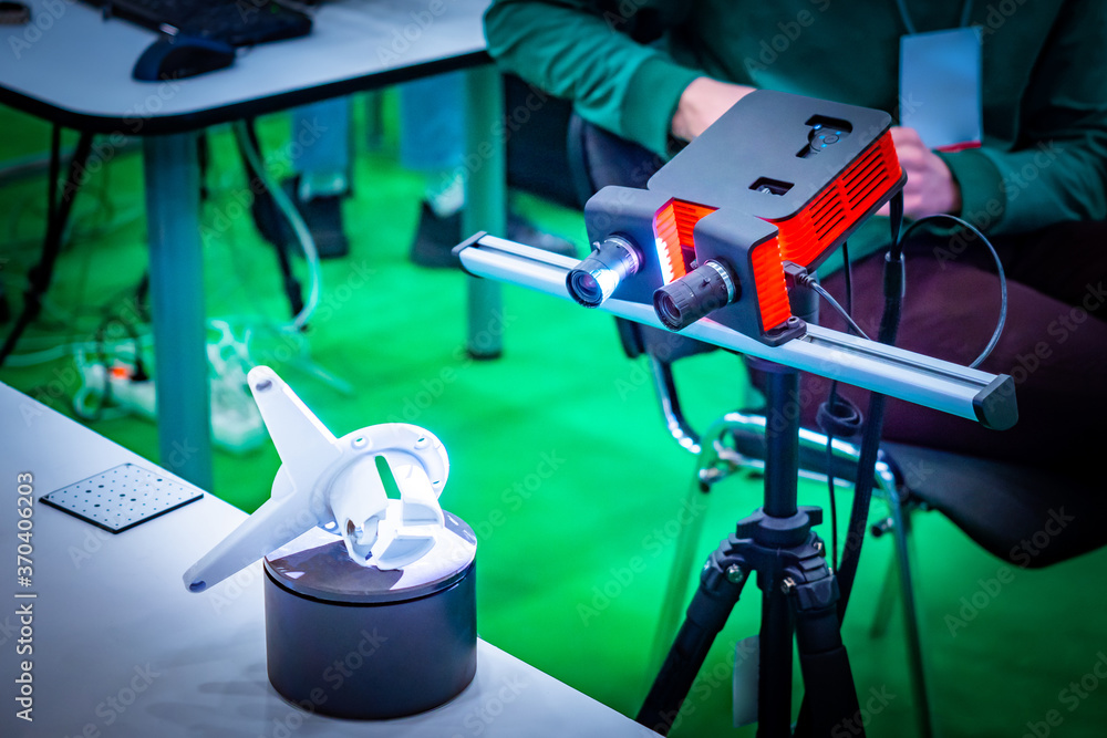 Poster engineer adjusts the device for 3d modeling. the device produces a three-dimensional layout of the p