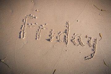 Friday written on beach sand