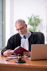 Old male judge working in courthouse