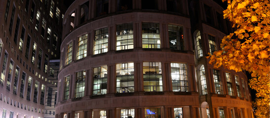 Panorama of the Central Branch of the Vancouver Public Library at night with yellow leaves in the...
