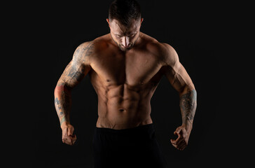 Fototapeta na wymiar Handsome muscular male bodybuilder on a black background. Strong man.