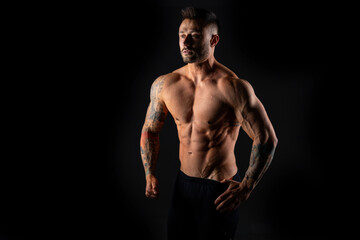 Fototapeta na wymiar Handsome muscular male bodybuilder on a black background. Strong man.